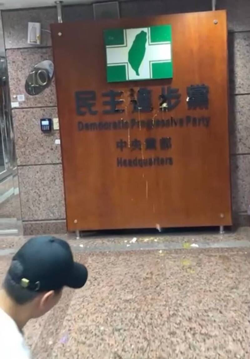 一名白衣男子在民眾黨反罷集會結束後，衝進民進黨中央黨部大樓扔雞蛋。（圖／讀者提供）