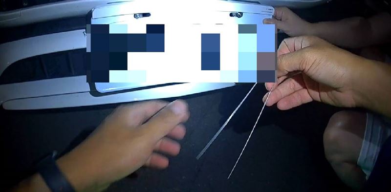 車主表示因支架損壞無法固定車牌,才暫時拆除,警方提供束帶幫忙固定車牌。(圖/翻攝畫面)