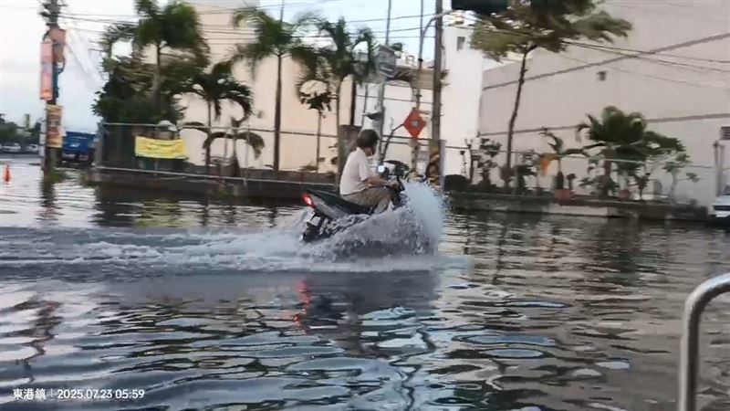 東港鎮清晨因海水倒灌,機車經過漫起水花。(圖/翻攝畫面)