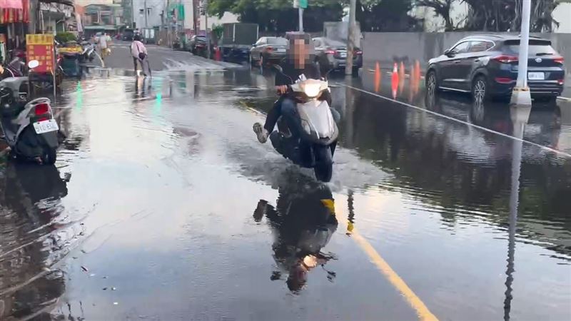 高雄旗津區同樣也因海水倒灌造成騎士也需涉水通過。(圖/翻攝畫面)