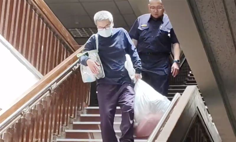 李文宗提著2大包個人物品，在家人及律師陪同下，離開台北地院。（圖／翻攝畫面）