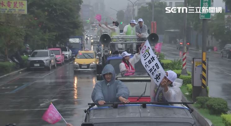 志工在雨中高舉著同意罷免布條。(圖/翻攝畫面)