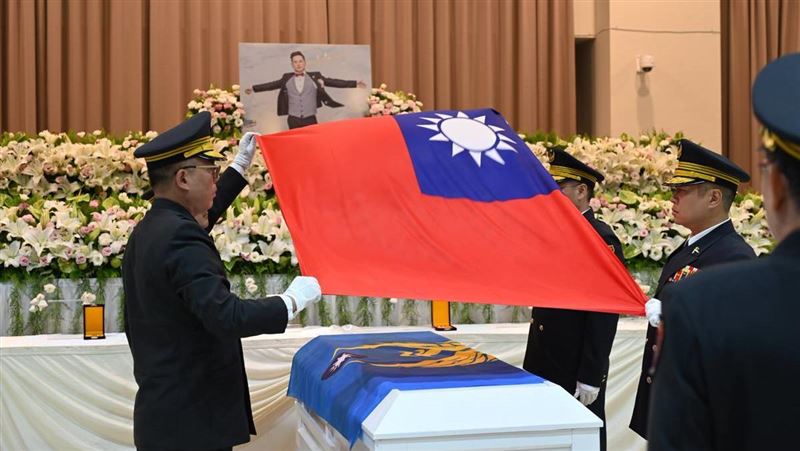消防局簡任技正鍾世銘及五位大隊長覆蓋消防旗及國旗。（圖／翻攝畫面）