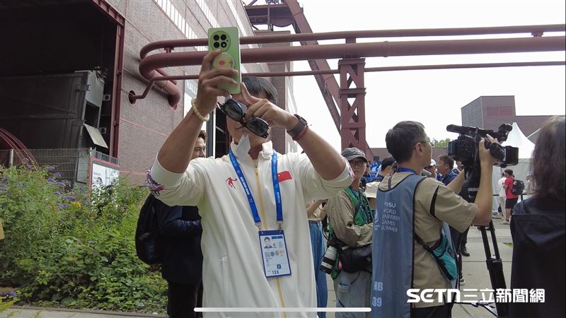 中國隊男子拿著手機拍攝我國駐德大使謝志偉頒發賀電。(圖/記者蔡厚瑄攝影)