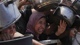 ▲加薩深陷嚴重飢荒如同煉獄，巴勒斯坦民眾在社區慈善廚房擠成一團，苦苦哀求一口粥。（圖／美聯社／達志影像）