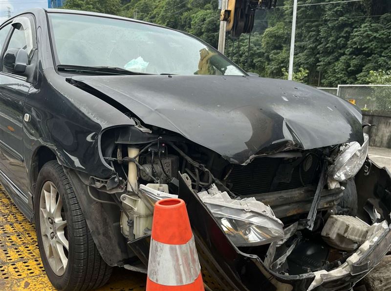 遊覽車疑似未注意車況就突然變換車道,導致左後方的小客車為了閃避而失控自撞護欄。(圖/讀者提供)