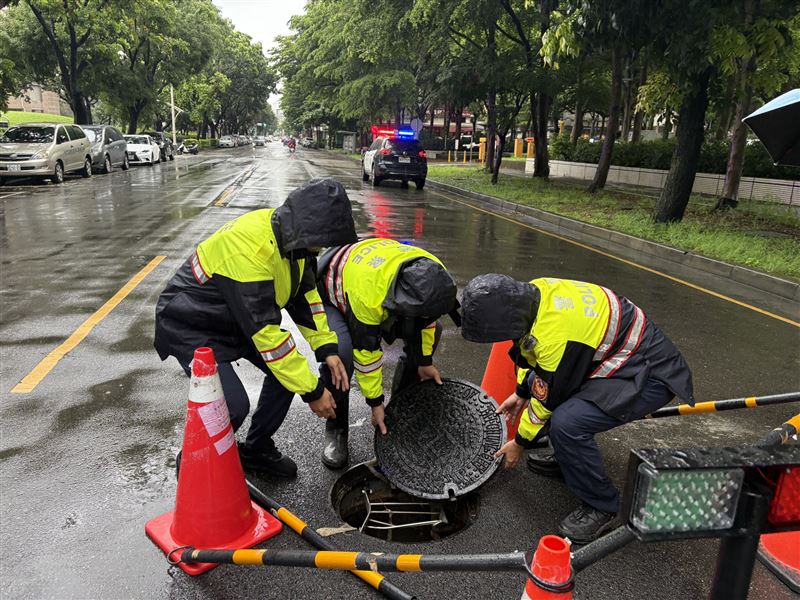 南屯所3名警員將人孔扛回歸位，以防意外發生。（圖／翻攝畫面）