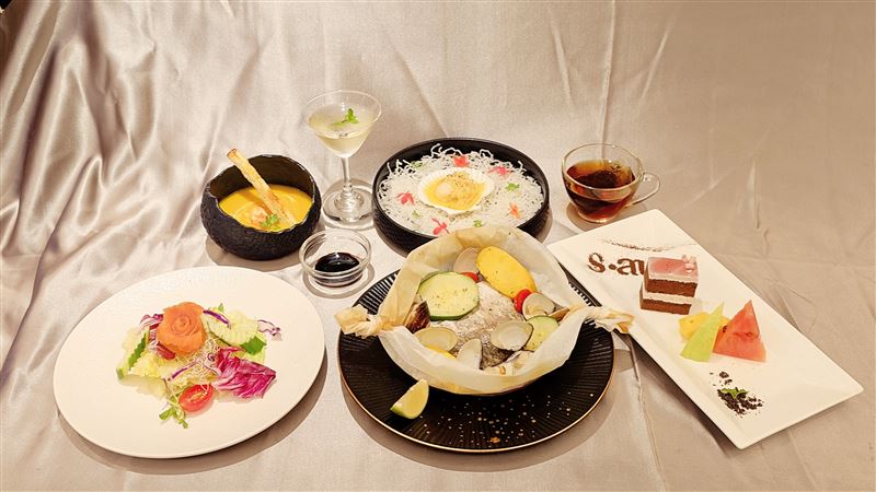 香樹花園酒店義式香料紙包魚採用去骨海鱸魚片，加入新鮮蛤蜊以及蔬菜等食材，以烘焙紙包裹起來，再以蒸烤的烹飪方式，保留食材的水分。（圖／飯店旅宿業者提供）