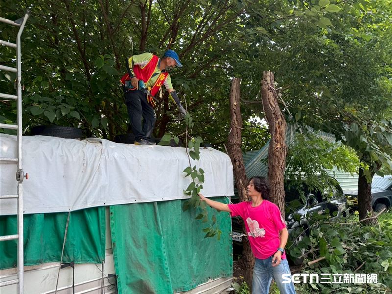 華山基金會義工們替張阿公整理貨櫃屋旁樹木的樹葉,還有換上全新的遮雨棚,讓阿公下雨天在屋內不必跟著淋小雨了。(圖/受訪者提供)