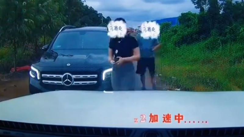 賓士女駕駛上前亮出證件,要求男子倒車讓路。(圖/翻攝自微博)