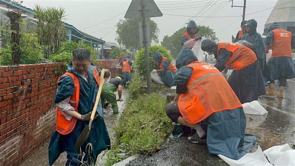 何博文水溝中協助清理淤泥的一幕，感動許多台南當地居民。（圖／民進黨提供）