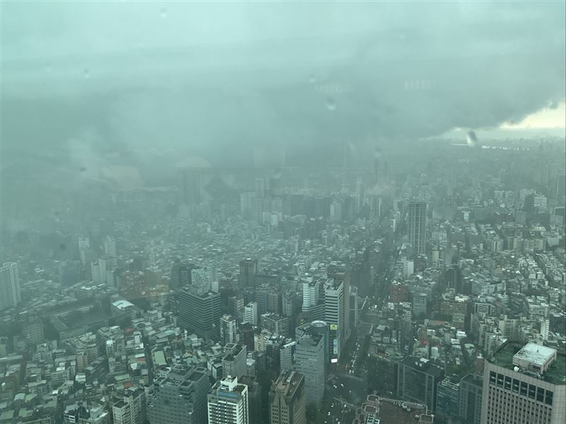 民眾在台北101大樓拍下天氣狀況,只見整個台北盆地被烏雲籠罩,瞬間天色昏暗。(圖/讀者提供)