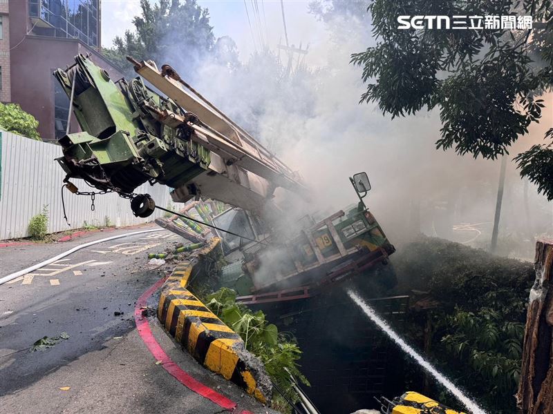 北市林男駕駛吊車行經溫泉路時冒濃煙，他跳車逃生導致吊車滑落邊坡。（圖／翻攝畫面）