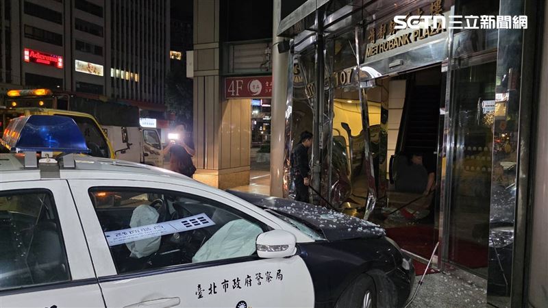 警車肇事,大樓玻璃門嚴重碎裂。(圖/翻攝畫面)