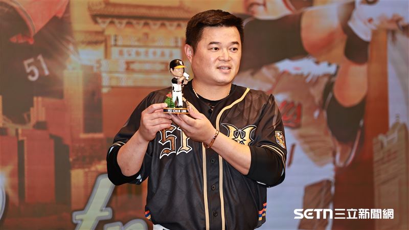 統一獅內野手胡金龍出席引退記者會，和自己的公仔合影。（圖／記者劉彥池攝影）