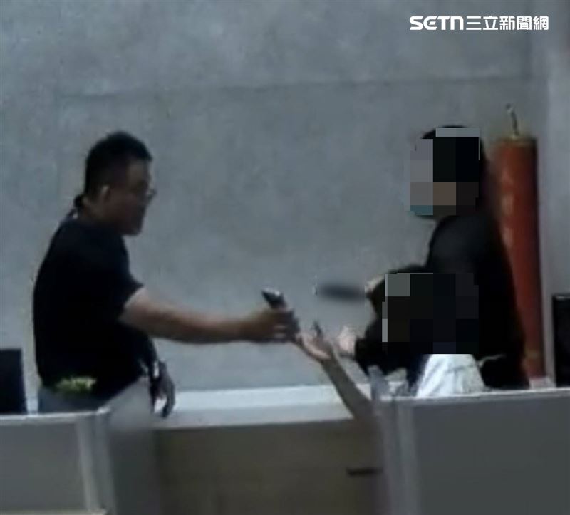 偵查隊長涂志宏持手機靠近吳男，抓準時機使出虎口奪刀，成功救出女員工。（圖／翻攝畫面）