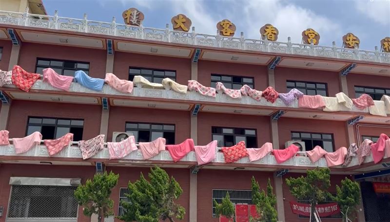近百件繽紛的棉被掛在欄杆晾曬，如同萬國旗在陽光下飄揚。(圖／翻攝畫面)