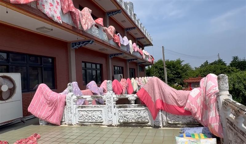 近百件繽紛的棉被掛在欄杆晾曬，如同萬國旗在陽光下飄揚。(圖／翻攝畫面)