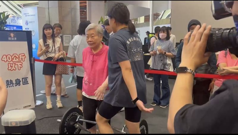 92歲鄭陳金梅阿嬤,挑戰25公斤跟30公斤硬舉成功。她賽前還認真熱身。(圖/高齡健康產業博覽會提供)