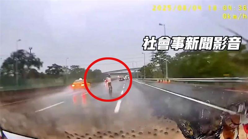 男子雨天站在國道中線車道擋車，相當危險。（圖／翻攝社會事新聞影音）