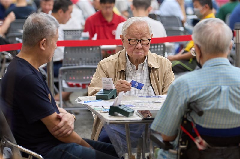 94歲台積電創辦人張忠謀重返牌桌,參加政大超級大專盃,張忠謀以「台大智慧」隊隊長身分出賽,精神奕奕全程投入,他曾與巴菲特、比爾蓋茲在牌桌上同場較量。(圖/翻攝自政大官網)