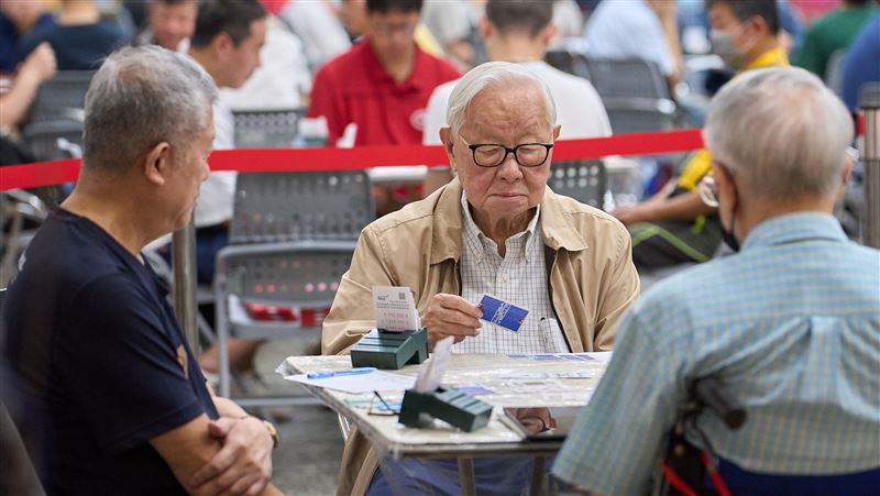 94歲台積電創辦人張忠謀重返牌桌,參加政大超級大專盃,張忠謀以「台大智慧」隊隊長身分出賽,精神奕奕全程投入,他曾與巴菲特、比爾蓋茲在牌桌上同場較量。(圖/翻攝自政大官網)