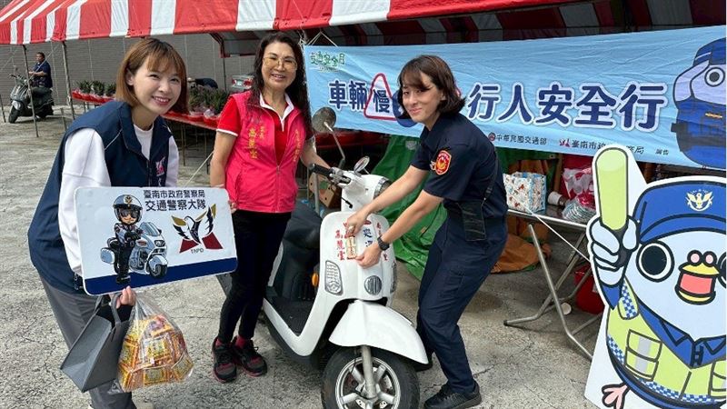 警察同仁幫民眾貼上反光貼紙。(圖/翻攝自臺南市政府警察局交通警察大隊粉絲專頁)