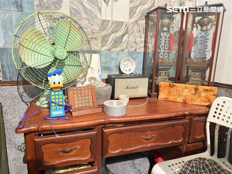 店內角落留著以前的桌子,還有蘇成業兒時玩的唐老鴨電話。(圖/記者李育道攝影)