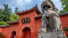 白馬寺山門全景。三洞弧牌樓式券門，單檐歇山頂，正面鑲嵌「白馬寺」匾額。寺門左右兩匹石馬遙遙相對。