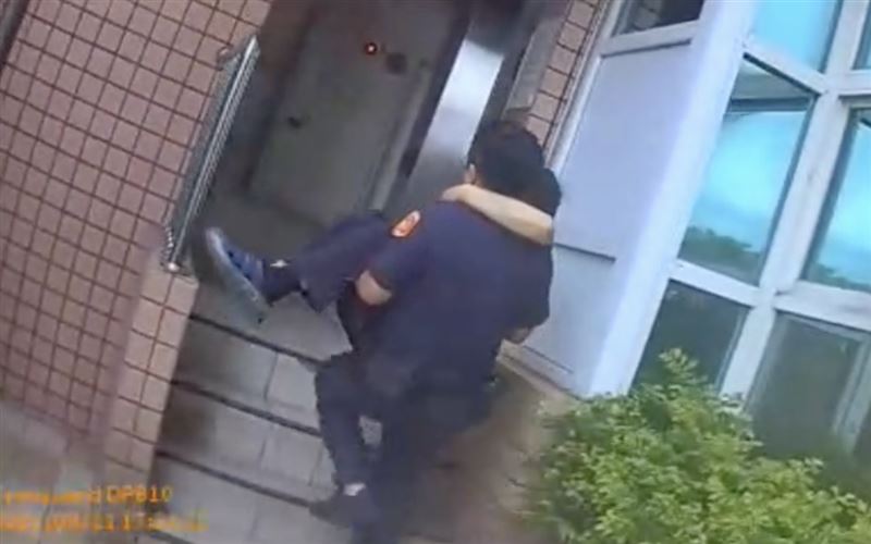 員警小心翼翼抱著林男，沿著樓梯一步一步往上爬。（圖／翻攝畫面）