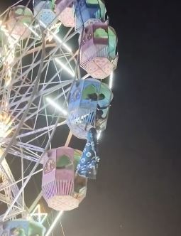 一名女子在搭乘摩天輪時不慎從車廂中摔出，整個人懸掛在約9公尺的高空，突然一名男子宛如「蜘蛛人」上身，迅速爬上摩天輪，成功將女子拉回車廂。（圖／翻攝自X＠ShortsShalini）