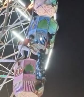 一名女子在搭乘摩天輪時不慎從車廂中摔出，整個人懸掛在約9公尺的高空，突然一名男子宛如「蜘蛛人」上身，迅速爬上摩天輪，成功將女子拉回車廂。（圖／翻攝自X＠ShortsShalini）