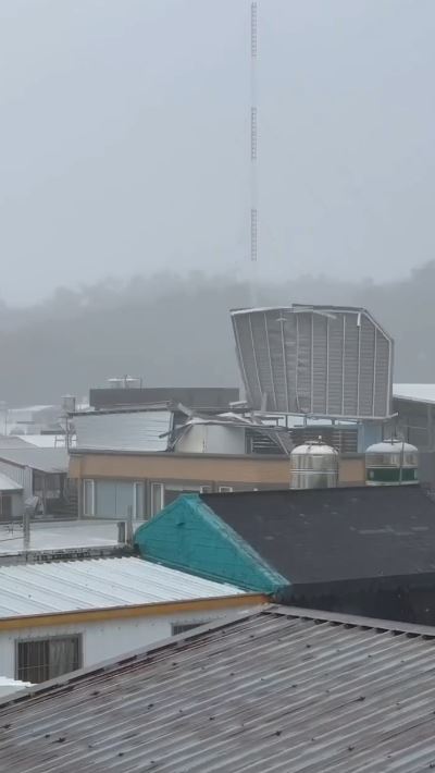 17級陣風讓鐵皮屋整片從90度變躺平,被吹掀後掉落街道。(圖/翻攝畫面)