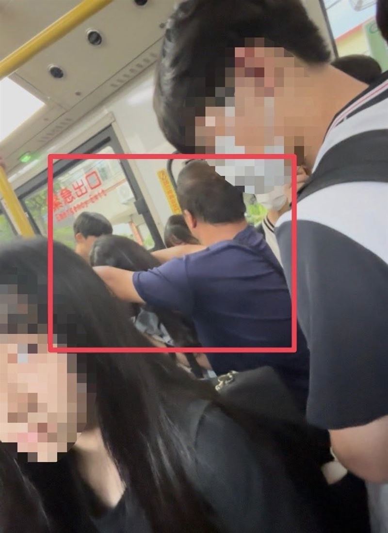 男子雙手環抱公車柱子的姿勢,將女學生圈在懷內。(圖/翻攝自謝志忠臉書)