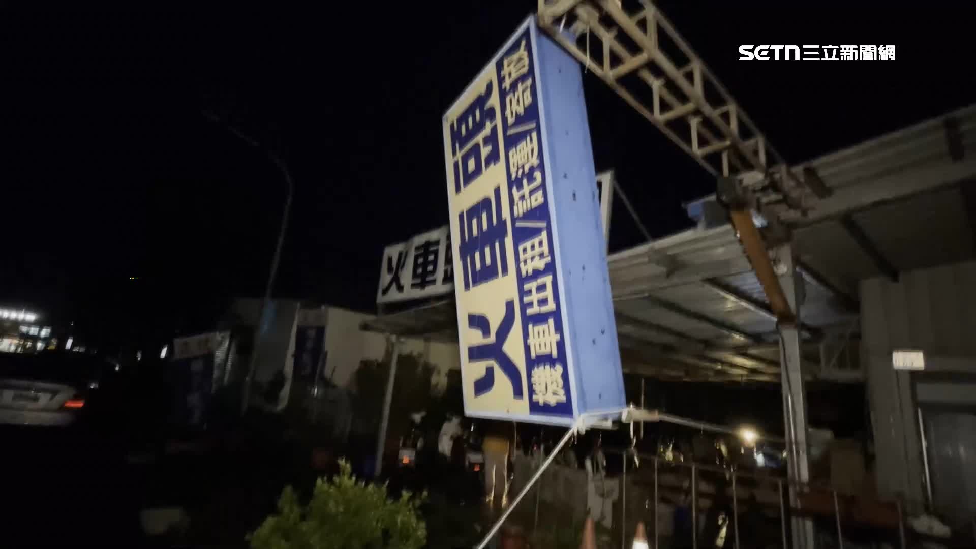 路邊招牌不敵強風豪雨肆虐，呈現垂直懸掛著