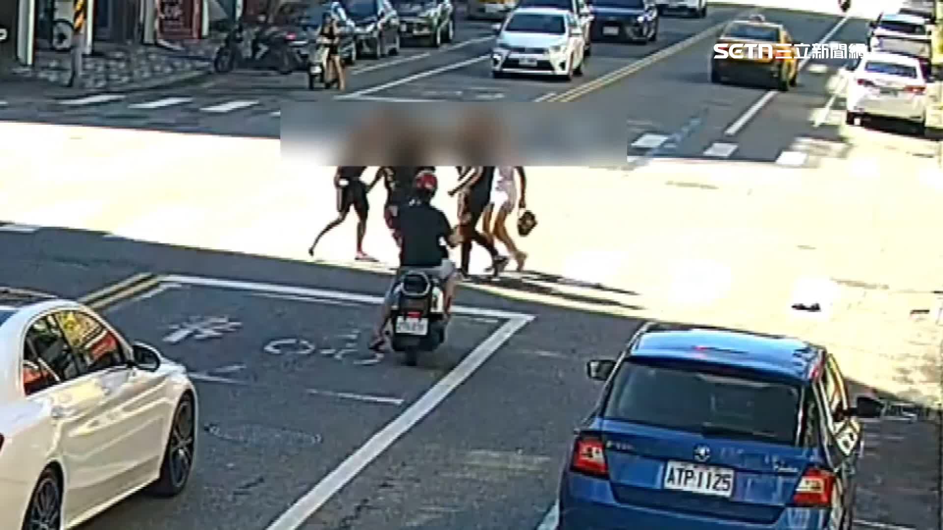五名男女不顧路上車輛，邊過馬路邊打，打到路中央
