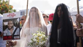 人質的未婚妻在母親陪同下，手持一塊印有伴侶馬坦·贊高克 (Matan Zangauker) 照片的牌子，在人質廣場舉辦象徵性的婚禮。（圖／美聯社／達志影像）
