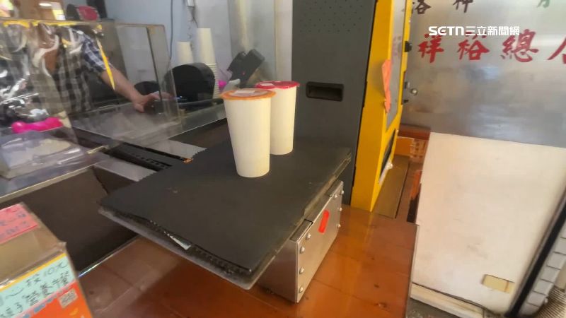 飲料放在傳輸帶，一個按鈕從店內送到店外，不用接觸民眾拿了就走