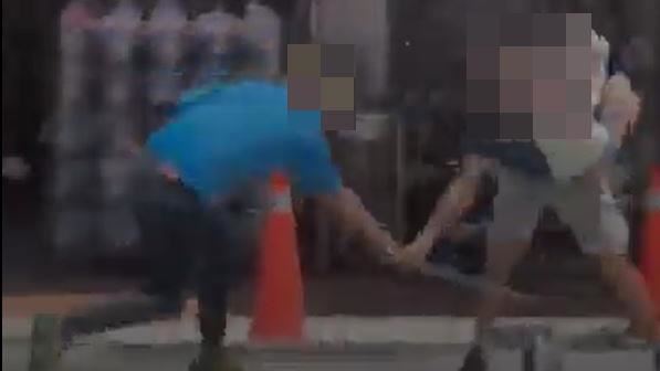 童男持角鋼架打抱著女兒的謝男。（圖／翻攝畫面）