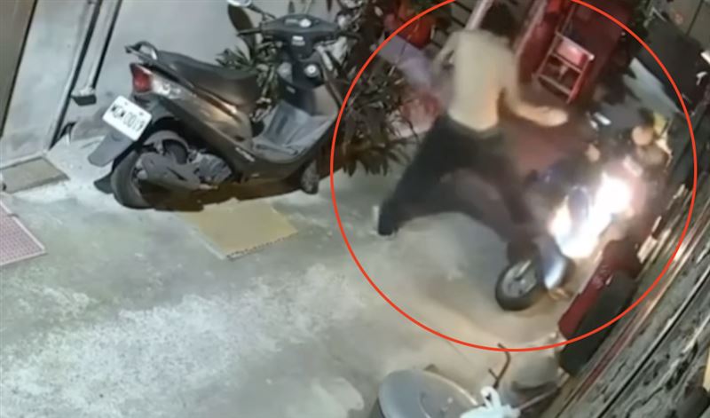 婦人騎機車經過時，男子突然動手推倒機車、用腳猛踹。（圖／翻攝畫面）