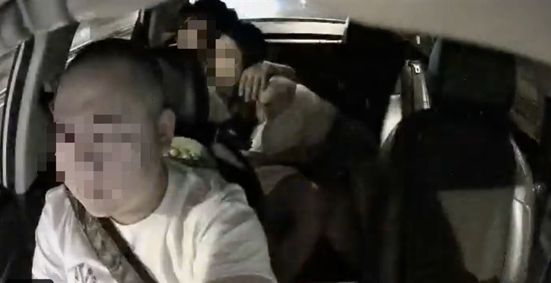 情侶在計程車後座調情甚至口愛，讓前座司機一臉無奈。（圖／翻攝自社會事件新聞影片X平台）