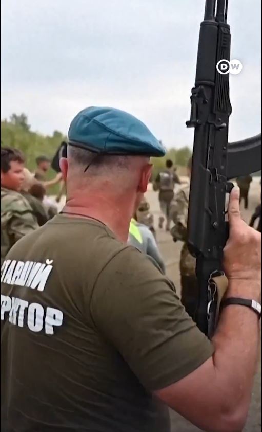 俄烏戰爭的退役軍人擔任教官，手持衝鋒槍培養兒童愛國情懷。(圖/翻攝X@DWnews)