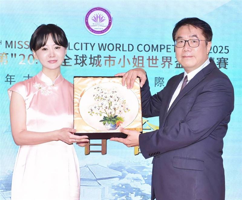 台南市長黃偉哲(右)致贈蘭花瓷盤給張如君，預祝選拔大賽圓滿成功。(圖／中華全球城市選拔協會提供)