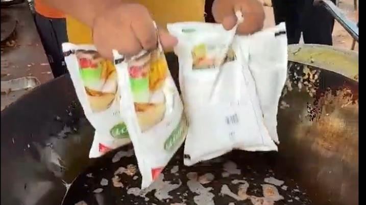 印度攤販以塑膠袋裝油直接投入油鍋，聽說此舉有聚於讓炸物更脆，口感更好，畫面一發，引起廣大網友反應，大家表示自己不吃，但一定會請朋友去吃，有人甚至表示，這種炸法，台灣也有。（圖／翻攝自社群媒體）