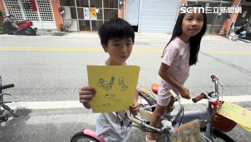 兩個小小孩賣畫還送糖果，鄰居們被逗得笑呵呵，有人掏錢相挺，也有人直呼「真懂事」。（圖／呂彥攝影）