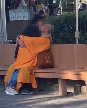 一名家長在兒童新樂園目睹身穿袈裟、光頭的男子，與一名女子當眾以「交疊」姿勢熱情擁吻
