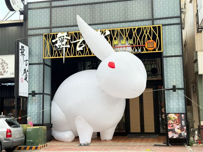 高雄華榮路上的「舞古賀鍋物專門店」門前出現一隻高約8公尺的白色巨兔。(圖/品牌業者提供)