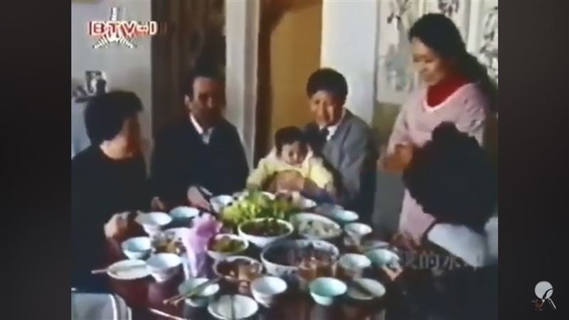彭麗媛從廚房上菜招呼客人說：「我們一塊吃吧」，習近平則抱著女兒坐在餐桌旁。（圖／翻攝自YouTube）