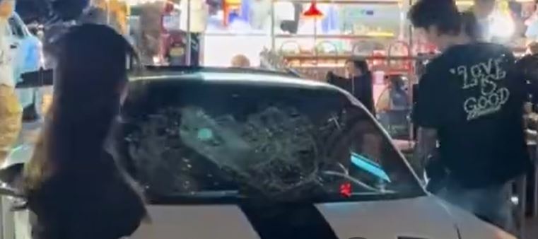 一名女子站在一輛跑車上，情緒激動地狂踹前擋風玻璃，最終前擋風玻璃破壞成蜘蛛網狀。（圖／翻攝自微博）