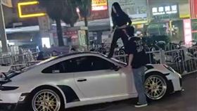 一名女子站在一輛跑車上，情緒激動地狂踹前擋風玻璃。（圖／翻攝自微博）